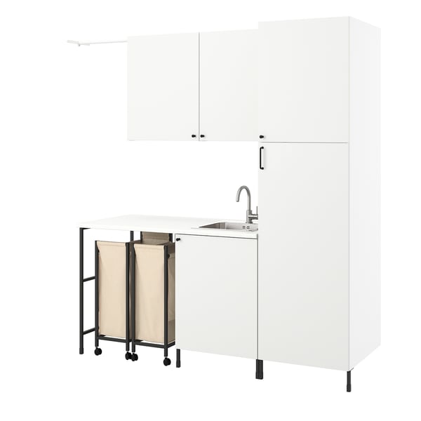 White laundry unit with sink, cabinets, and rolling bags for sorting clothes.