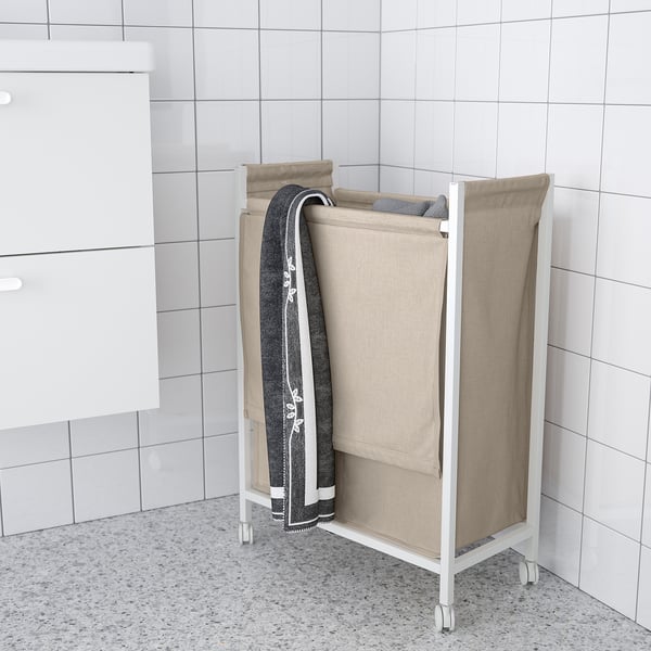 White ENHET laundry bag on wheels, beige, rectangular, with gray towel, in bathroom.