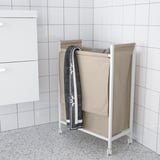 White ENHET laundry bag on wheels, beige, rectangular, with gray towel, in bathroom.