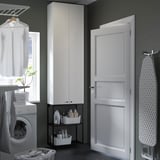 Modern white laundry room setup with tall and wall cabinets, white washing machine, clean design.