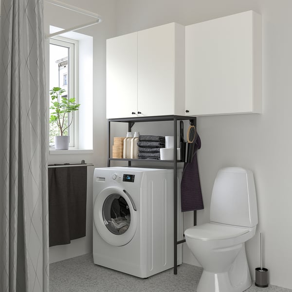 Modern bathroom with ENHET white cabinet combo, washing machine, and toilet. Minimalist design, efficient storage.
