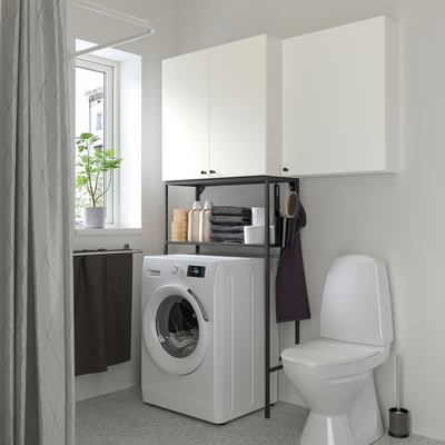 Modern bathroom with ENHET white cabinet combo, washing machine, and toilet. Minimalist design, efficient storage.