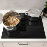 Induction kitchen with two pots, digital controls, extractor.