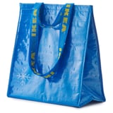 Blue FRAKTA bag, textured, with yellow handle patterns, stands upright with two handles.
