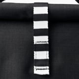 Black striped bag with sturdy handles displayed closely, showcasing its quality texture and design.