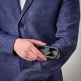 Person in suit holds reusable lint brush, ready to clean clothes effortlessly.