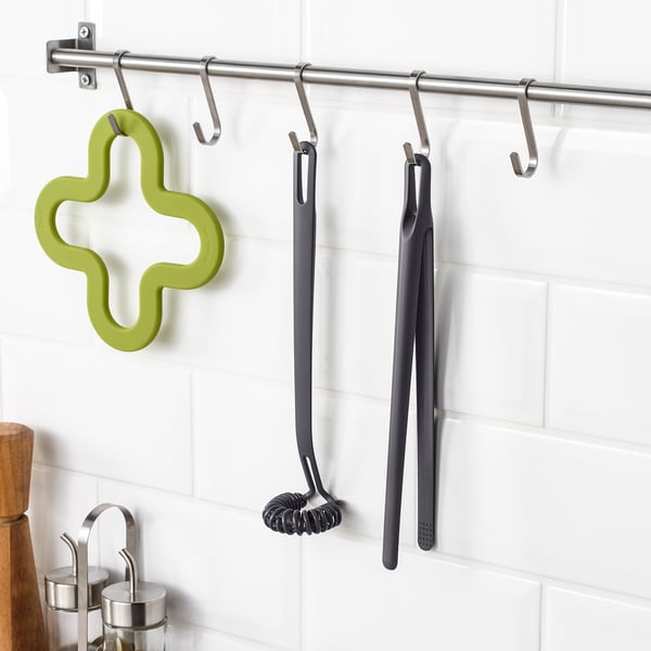 Kitchen utensils on hooks: green cross tool, black tongs, FULLÄNDAD.