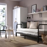 Modern minimalist bedroom: white wardrobe, black day-bed, light rug. Fyrsdal day-bed is compact, neatly fits space.