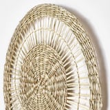 Handwoven sedge wall art, circular. Intricate natural design, high craftsmanship.