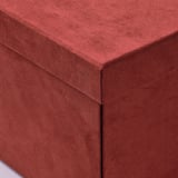A close-up of a plush, reddish-brown velvet storage box. Its smooth texture and clean, square edges highlight its high-quality craftsmanship.