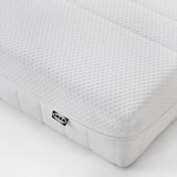 Close-up of IKEA foam mattress, white, with textured surface and black label.