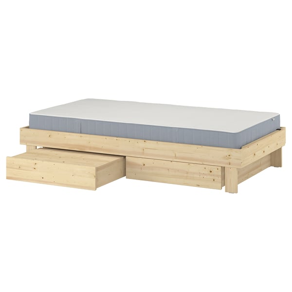 A GLAMBERGET extendable bed in natural wood with a white mattress, featuring two storage drawers underneath.