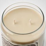 Creamy, beige candle in clear glass jar with two wicks. Elegant label and smooth finish.