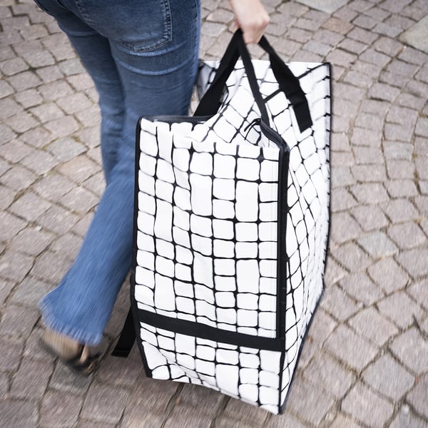 Large white bag with black handles and grid pattern, good for carrying or backpacking.