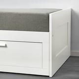 White day-bed with gray cushioned top, featuring a fitted sheet design for easy washing.