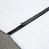 Close-up of a neatly folded gray elastic strap from a high-quality fitted sheet, focused on its durable, textured finish.