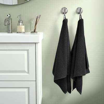 Cozy bathroom with white cabinet, GULVIAL towels, green wall.