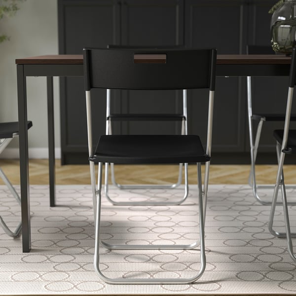 Foldable chair, metallic legs, black seat & back. Carry handle, up to 100 kg.