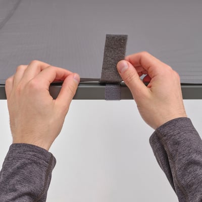 Hands attach a canopy using hook-and-loop fasteners to a metal frame of a GUNNÖN gazebo.