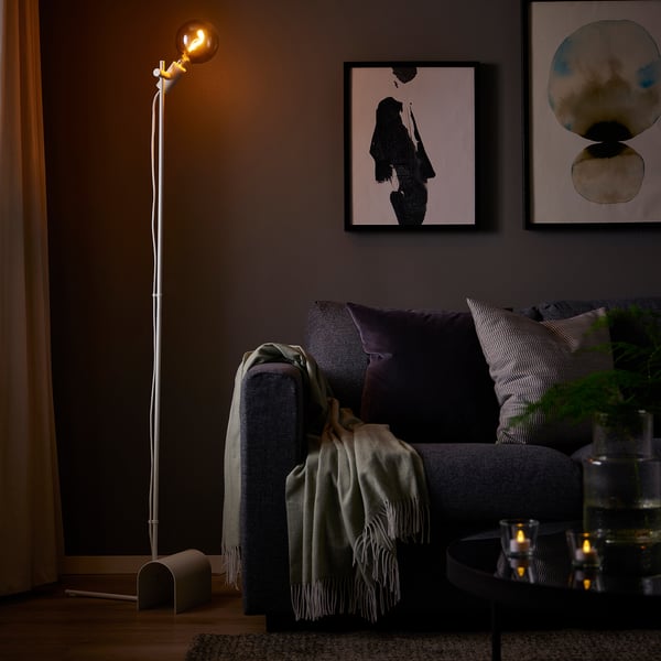 Living room with HÅRSLINGA floor lamp. Adjustable silver design casts soft light.