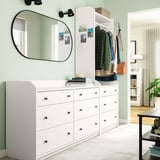 Modern bedroom featuring white HAUGA chest of 6 drawers and wardrobe with clothes, mirror, and decor on light green walls.