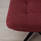Close-up of red-brown fabric on upholstered furniture, showcasing texture and quality.