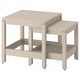 Two light beige wooden tables, one larger and one smaller, nested together with clean, simple lines, perfect for space-saving.