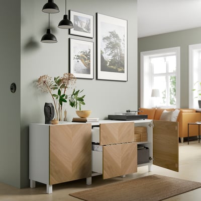 Modern living room with wooden cabinet, record player, pendant lights, and nature photos.