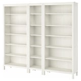 Two white wooden HEMNES bookshelves with adjustable shelves, standing side by side.