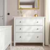 HEMNES chest drawers in bedroom, 3 drawers, against pink wall, near bed.