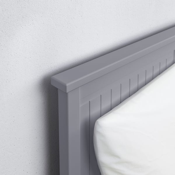Modern grey bed with clean lines and smooth finish against a white wall.