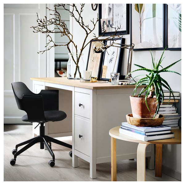Home office: white desk, black chair, wooden top, drawers, plant, books, decorations.