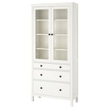 White HEMNES pine wooden display cabinet with glass doors, multiple drawers.