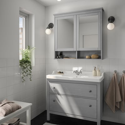 Modern gray HEMNES bathroom vanity with mirror cabinet, plant, & towels.