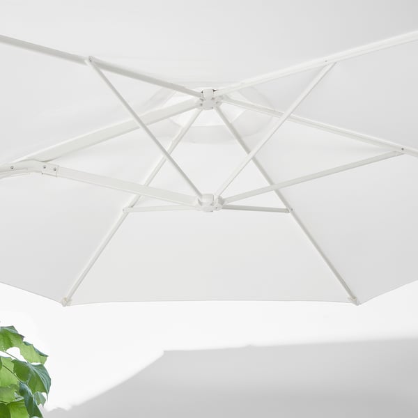 White parasol, open and angled, showing robust frame and vented design.