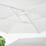 White parasol, open and angled, showing robust frame and vented design.