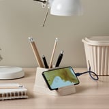 Desk organizer holds pens and charges phone.