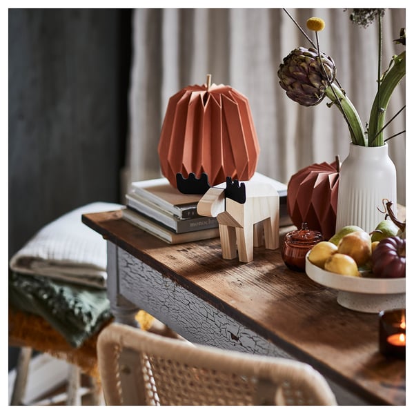 Decorative autumn pumpkins, HÖSTAGILLE, rustic orange, paper. Small, folded, atop books.