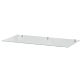 A clear IDANÄS glass shelf, square-shaped, supported by four metal brackets.