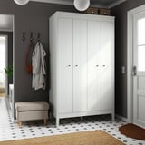 Neat entryway with white IDANÄS wardrobe, hooks, stool, patterned rug, coat and bag on hooks.