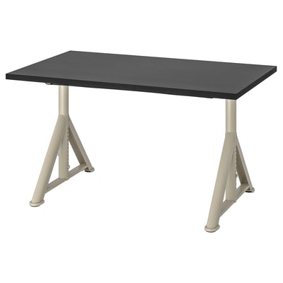 An idaho black desk with beige metal legs, adjustable and angled for stability.