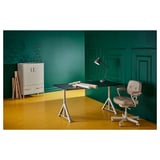 Modern green office setup with IDÅSEN desk, white legs, beige chair, lamp, and storage unit with decorative items.