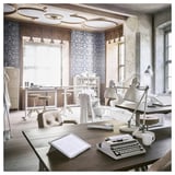 A vintage-inspired workspace a wooden desk with a typewriter, lamp, and notepad. The room has ornate patterned wallpaper and wooden accents.