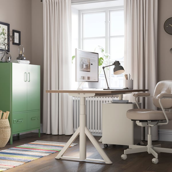 Home office with IDÅSEN desk, chair, and decor. Warm rug, large window, calm colors.