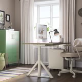 Home office with IDÅSEN desk, chair, and decor. Warm rug, large window, calm colors.