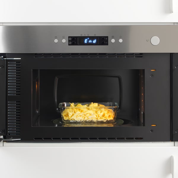 Built-in microwave oven with oven-safe glass dish inside, illuminated digital display shows end.