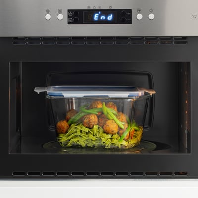 Microwave-safe glass container with lid heats meal, snap-lock lid.