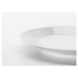 Close-up of sleek, white porcelain plate edge from IKEA 365+, smooth finish reflects light, showcasing durability and elegant simplicity.