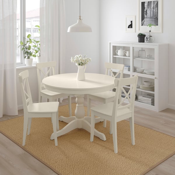 Small white INGATORP dining set with 4 chairs fits neatly under the table. Bright, clean look with natural light and flowers.