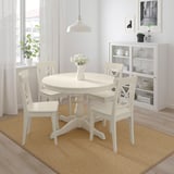 Small white INGATORP dining set with 4 chairs fits neatly under the table. Bright, clean look with natural light and flowers.